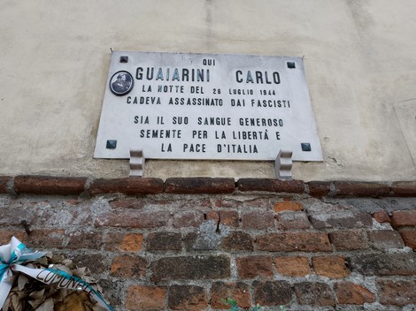 Lapide commemorativa di Guaiarini Carlo, assassinato dai fascisti nel 1944, situata su un muro di mattoni.