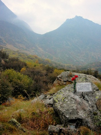 Lapide commemorativa di Strippoli, immersa in un paesaggio montano autunnale.