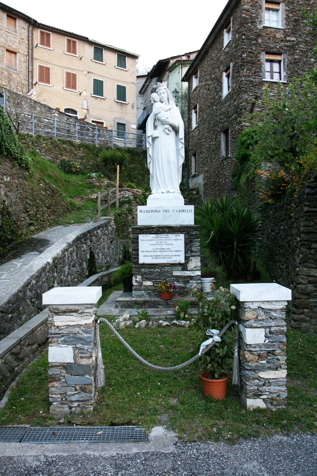 Lapide commemorativa con statua, simbolo di salvezza e resistenza in un contesto storico e culturale.