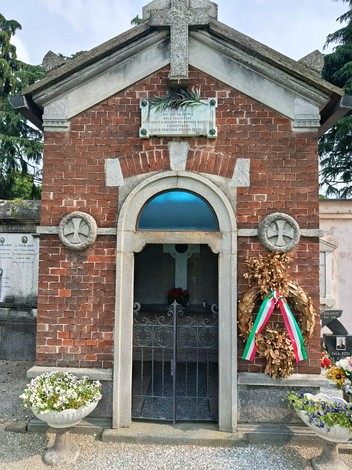 Cappella dei caduti di Muggiò, monumento in mattoni con decorazioni e allestimento floreale in onore dei defunti.