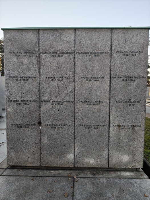 Monumento commemorativo al "Campo della Gloria" con nomi incisi su una parete di pietra grigia.