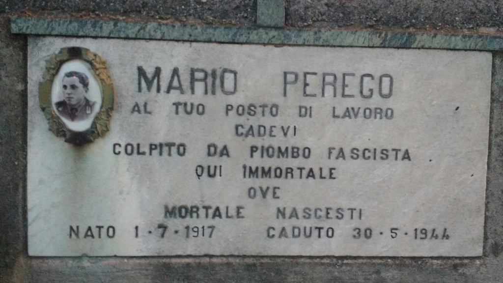 Lapide in marmo con fotografia ovale di un uomo e iscrizione dedicata a Mario Perego.