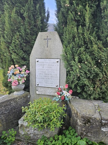 Monumento ai caduti per la Libertà di Coldimosso, circondato da piante e fiori ornamentali.