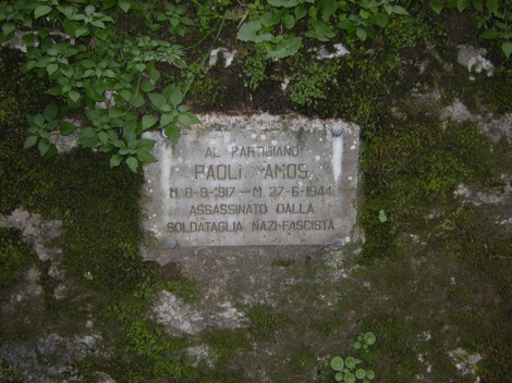 Lapide commemorativa a Paoli Amos, partigiano assassinato dai soldati nazifascisti. Memoria di resistenza e sacrificio.