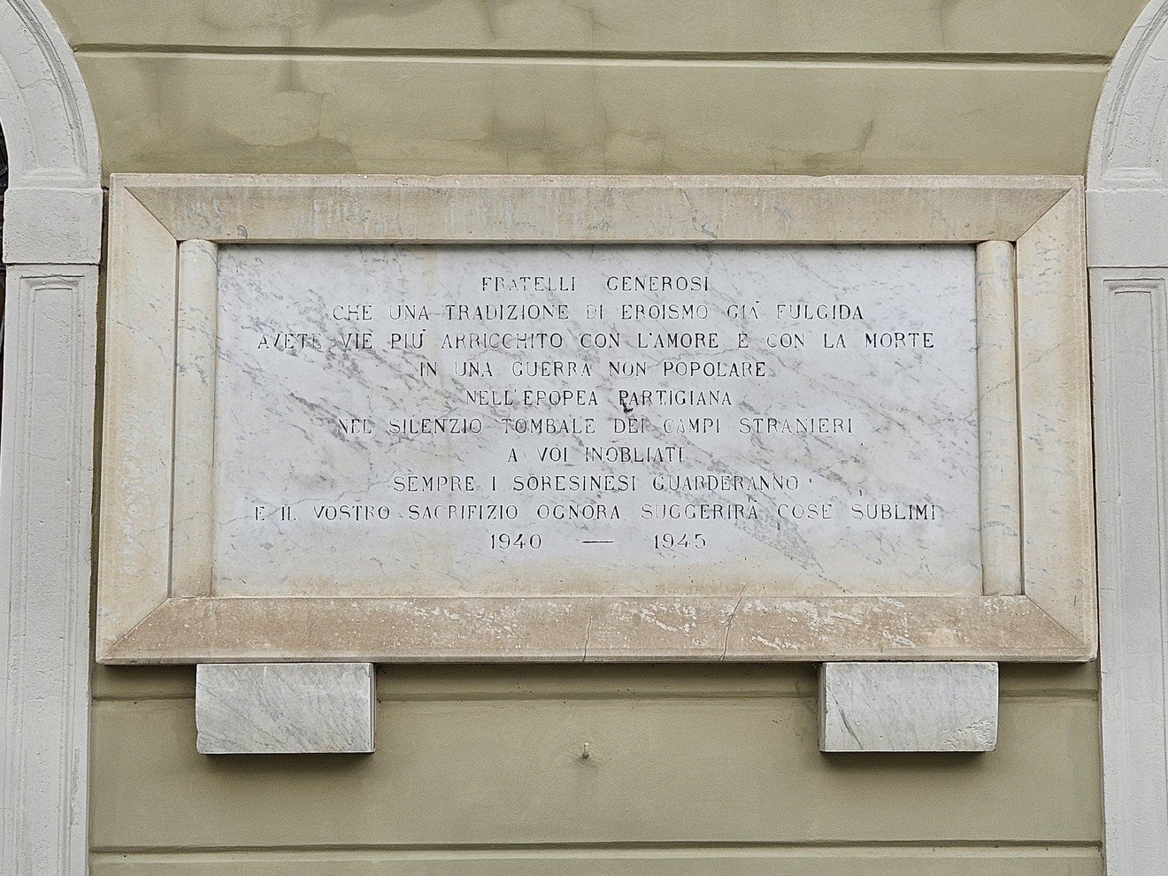 Lapide commemorativa dedicata ai caduti per la libertà, con incisioni su marmo e un design sobrio.