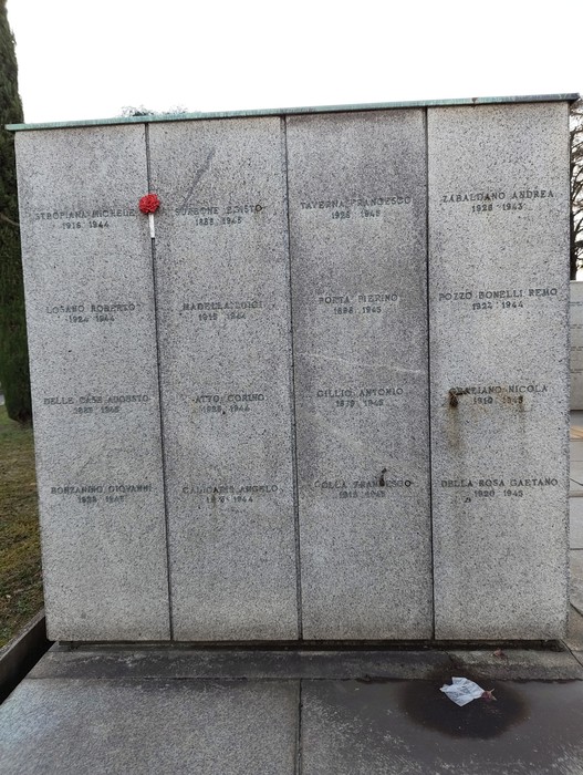 Monumento commemorativo con epigrafi di caduti, Campo della Gloria, in un contesto sobrio e rispettoso.