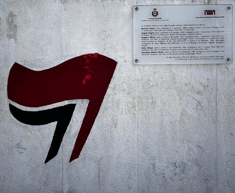 Murale dedicato ai fratelli Vitrani, con simboli in rosso e nero su sfondo chiaro.
