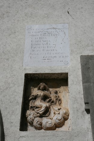 Lapide di San Giovanni della Vena con ornamenti scolpiti e incisioni storiche, esempio di arte rinascimentale.