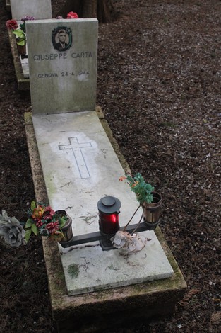 Tombe perpetue dedicate ai caduti per la Libertà, con decorazioni floreali e candele accese.