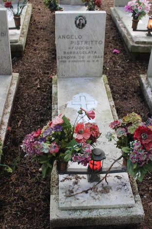 Tombe con fiori decorativi e lanterna, commemorano i caduti per la Libertà in un cimitero.