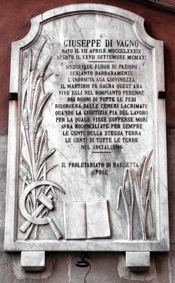 Lapide commemorativa di Giuseppe Di Vagno, con simboli e testo che ne celebrano la memoria.