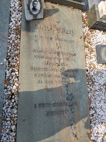Tomba di Celio con incisioni commemorative su pietra e decorazioni su fondo ghiaioso.