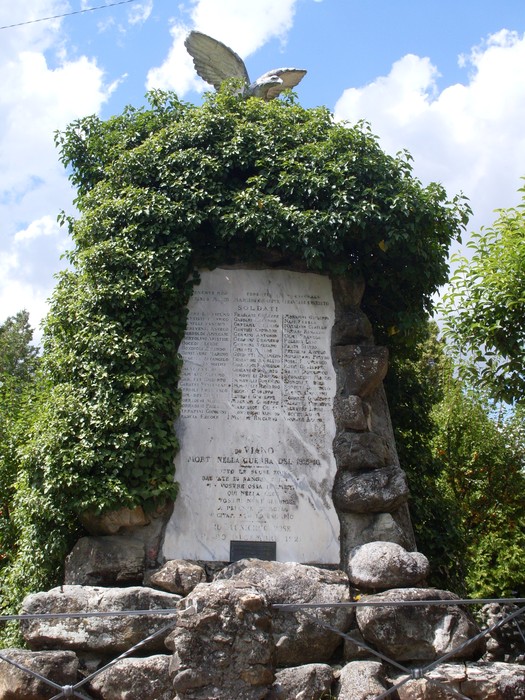 Monumento ai Caduti di Viano, dedicato alla memoria dei soldati, adornato da vegetazione e un’aquila in cima.