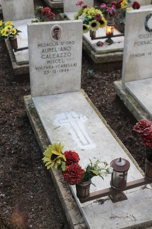 Tombe dei caduti per la Libertà, con fiori e candele adornano le lapidi in un luogo di commemorazione.