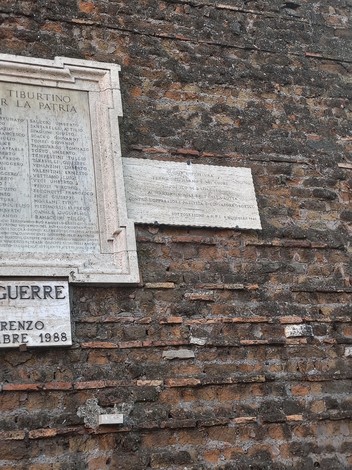 Lapide commemorativa dei caduti per la Libertà di San Lorenzo, affissa su un muro di mattoni.