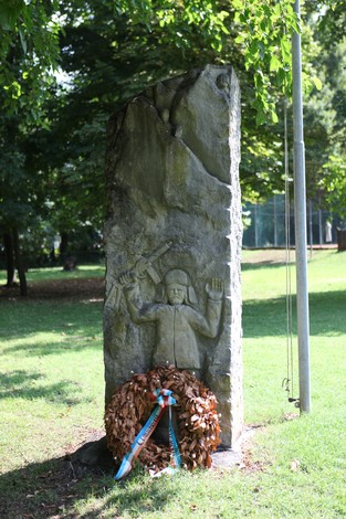Il Monumento ai caduti per la libertà, raffigurante una scultura commemorativa circondata da un omaggio floreale.