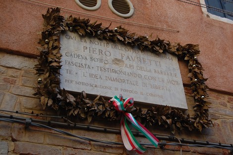 Lapide commemorativa con foglie decorative, dedicata a Piero Favretti, in ricordo degli eventi del 1944.