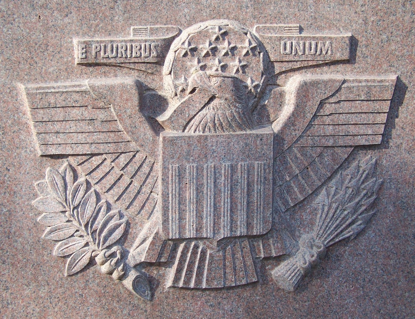 Sigillo degli Stati Uniti su una lapide del Cimitero Militare Americano, simbolo di onore e memoria.