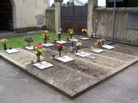 Sacrario del cimitero di Badia a Settimo, con fiori e lapidi in un’atmosfera di commemorazione e rispetto.