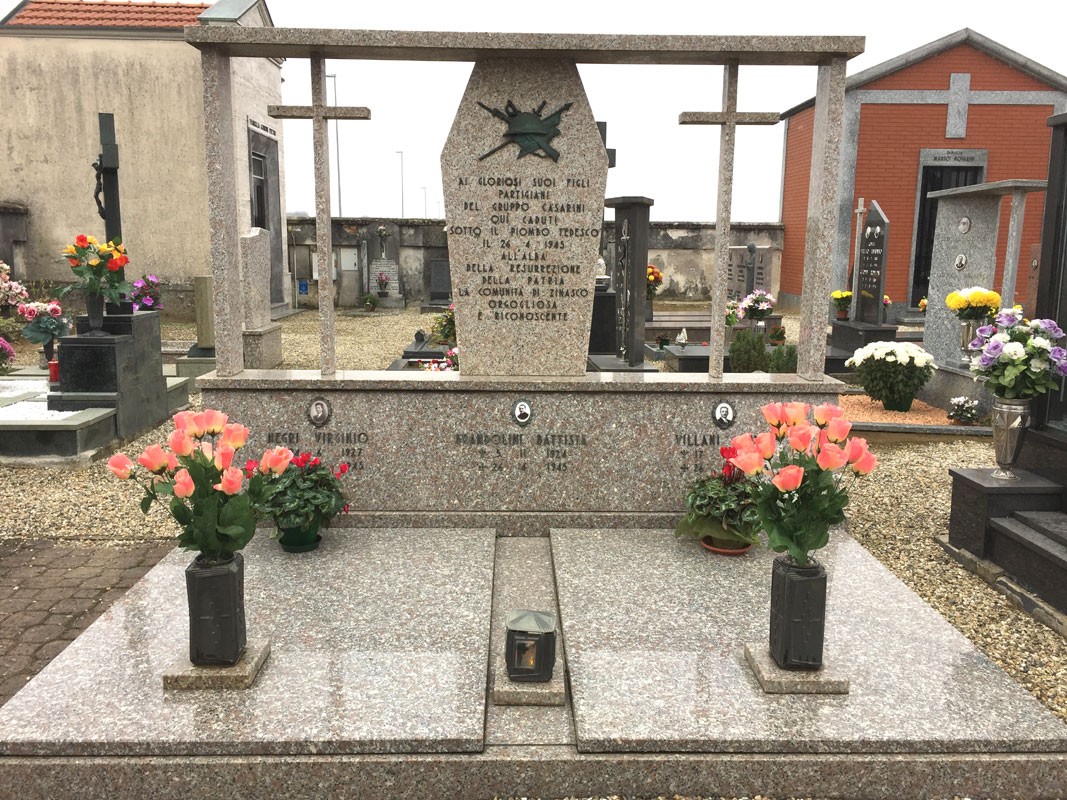 Monumento commemorativo dedicato ai caduti del gruppo Casarini, con fiori e croci nel cimitero.