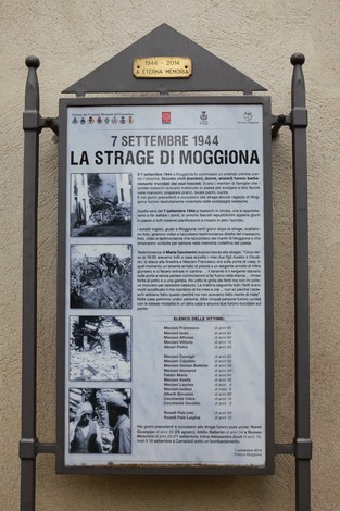 Monumento commemorativo delle vittime della strage di Moggiona, con informazioni storiche e fotografie.