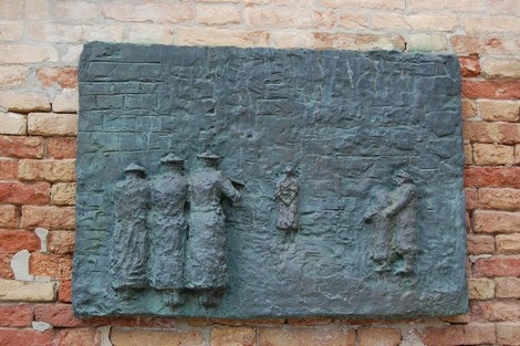 Monumento all'Olocausto con rilievi che rappresentano figure umane in una composizione drammatica e significativa.