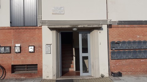 Lapidi commemorative ai fratelli Ruscello su un edificio, visibile l'ingresso e le cassette postali.