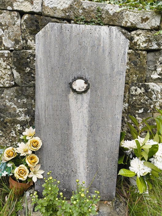 Sepolcro commemorativo in memoria delle vittime dell'eccidio di Vallucciole, arricchito da fiori.