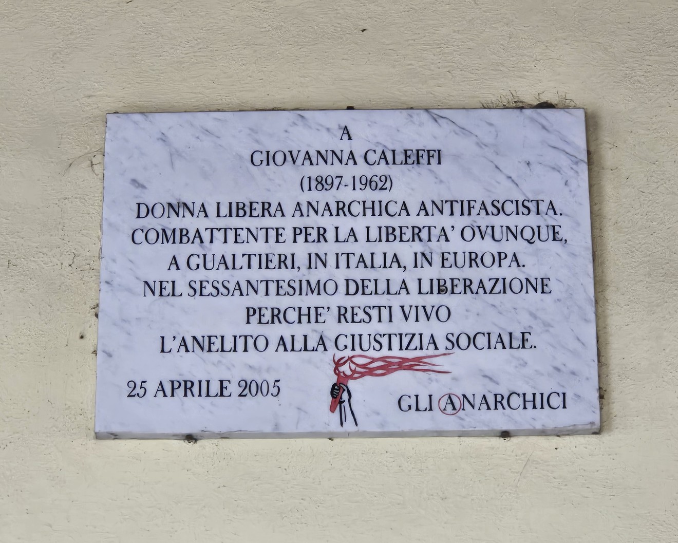 Lapide commemorativa dedicata a Giovanna Caleffi, attivista antifascista e anarchica, situata in un contesto pubblico.