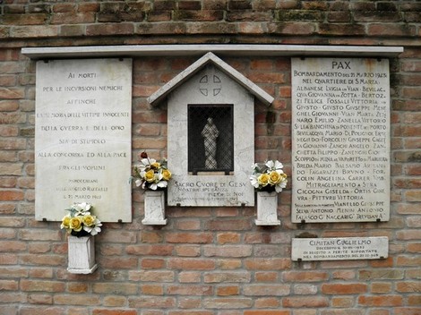 Lapidi commemorative per le vittime del bombardamento di Santa Marta, adornate con fiori.