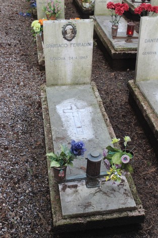 Tomba con iscrizioni e fiori, dedicata ai caduti per la Libertà, in un cimitero commemorativo.