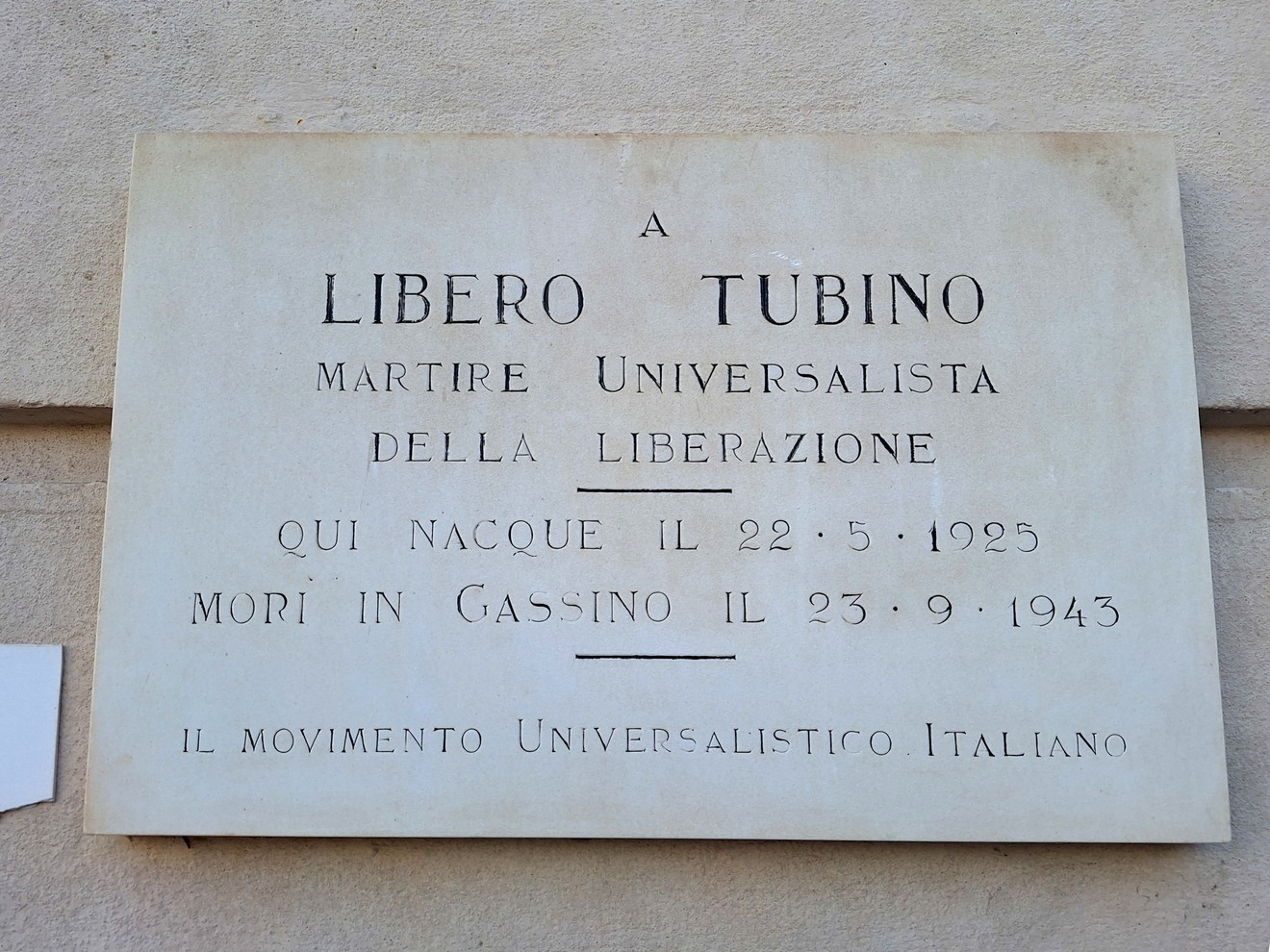 Lapide commemorativa dedicata a Libero Tubino, martire della liberazione, situata su un muro.