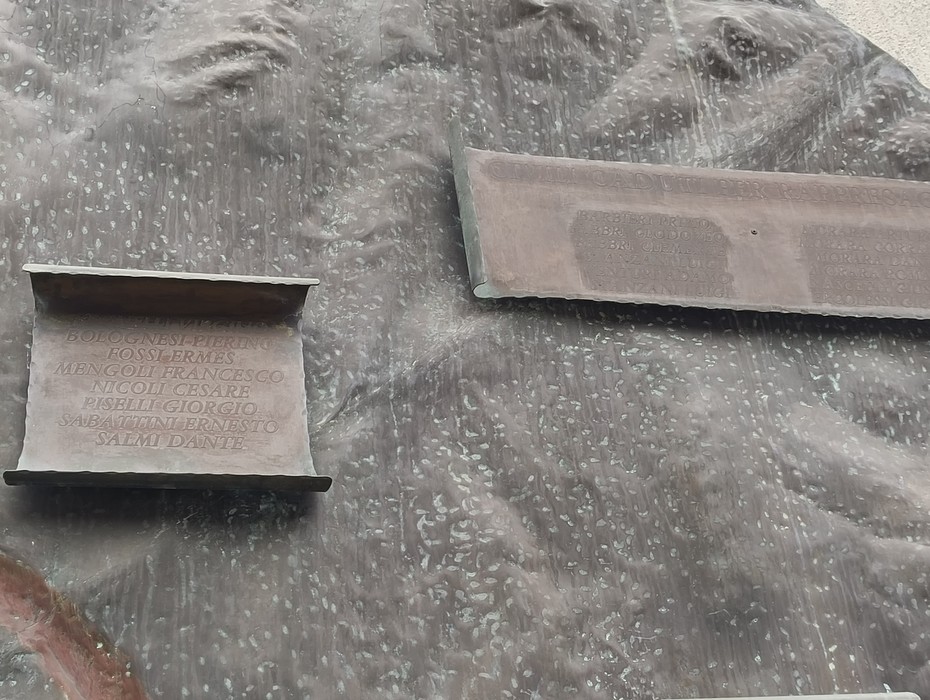 Monumento ai partigiani caduti di Pianoro, con iscrizioni commemorative su una superficie in bronzo.