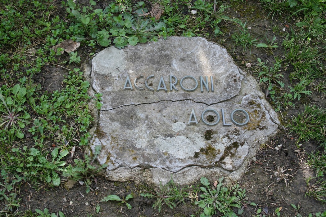 Monumento in pietra nel cimitero di Stia, dedicato a Aolo Accaroni. Atmosfera di memoria e rispetto.