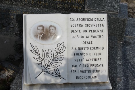 Monumento commemorativo ai fratelli Pellegrini, con iscrizioni e immagini, simboleggia il sacrificio e la memoria.