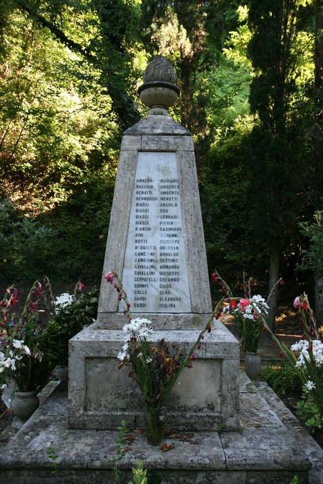 Monumento dedicato alle vittime dell'eccidio di Guardistallo e Montescudaio, con fiori commemorativi.