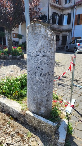 Cippo commemorativo dedicato a Joseph Kennedy, situato in un contesto urbano.