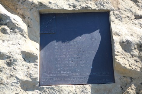 Masso antifascista con una placca commemorativa su un grande masso roccioso in un contesto naturale.
