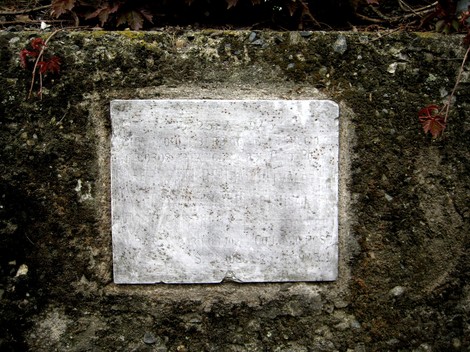 Lapide in commemorazione di Ferrotti, Foscale e Rodini, incastonata in un muro di pietra.