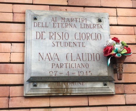 Lapide commemorativa dedicata a De Risio e Nava, martiri della libertà. Decorata con fiori.