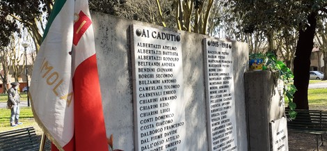 Monumento commemorativo ai caduti di Imola, con nomi e omaggi floreali.