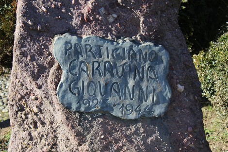Cippo commemorativo in pietra dedicato a Giovanni Caravina, partigiano attivo nel 1944.