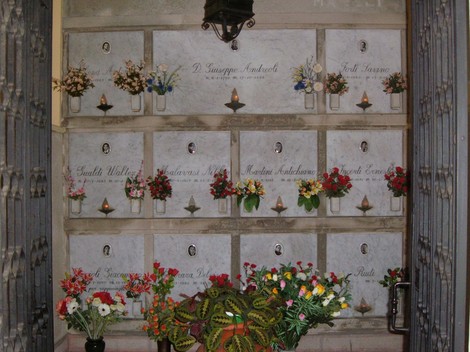 Sacrario dei partigiani di San Possidonio con lapidi marmoree e fiori freschi in omaggio.