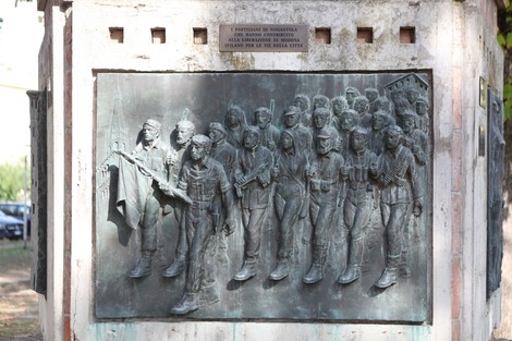 Monumento alla Resistenza con bassorilievo che ritrae partigiani in marcia, simbolo di lotta e libertà.