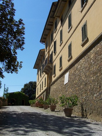 Lapide di Villa Santinelli, storica villa con facciata gialla e terreno circostante alberato.