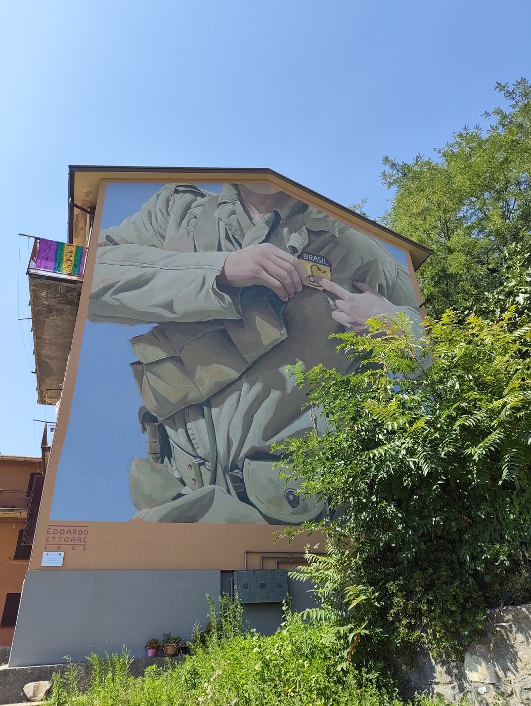 Murale su parete di edificio, raffigura un soldato con divisa militare e iscrizione alla base.