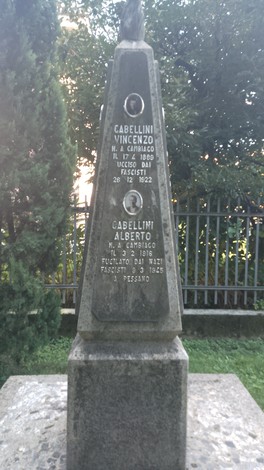 Monumento agli antifascisti con una stele commemorativa in una zona verdeggiante.