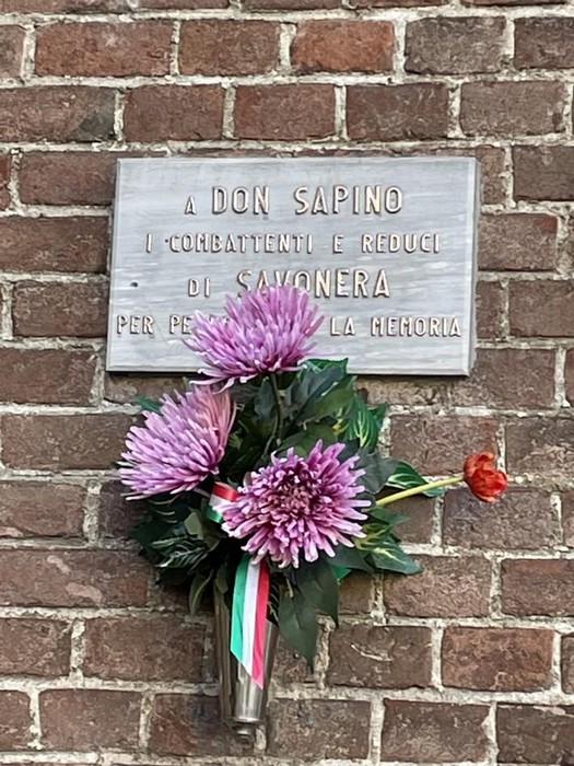 Lapide commemorativa a Don Sapino con fiori, in memoria dei collaboratori e reduci di Savonera.