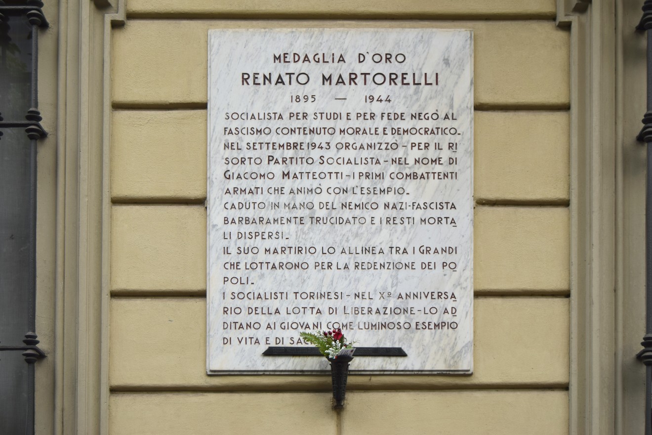 Lapide commemorativa dedicata a Renato Martorelli, con dettagli sulla sua vita e il suo impegno politico.
