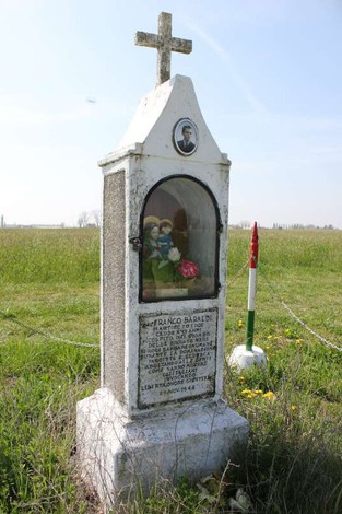 Tabernacolo dedicato a Baraldi, con statue e iscrizioni in un contesto naturale.